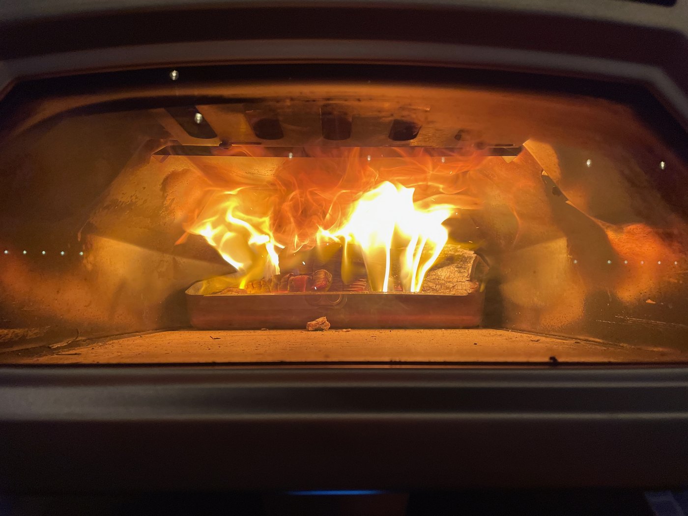 Flames rolling through the mouth of CJ's backyard wood-fired pizza oven, logs burning on the stone hearth.